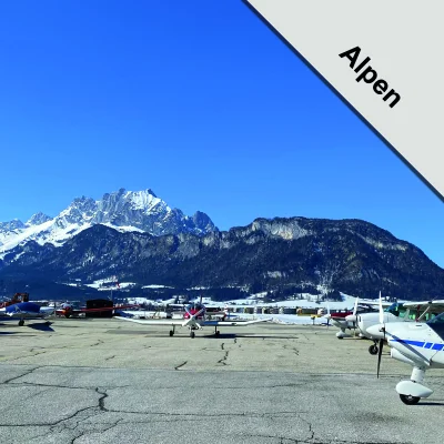UL-Flugzeuge am Flugplatz vor verschneitem Alpenpanorama bei klarem Himmel
