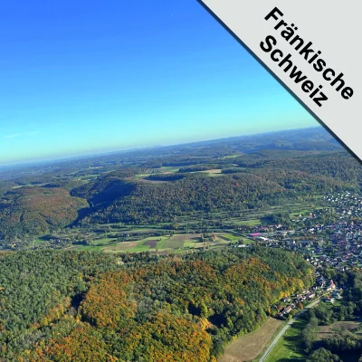 Luftaufnahme der Fränkischen Schweiz mit sanften Hügeln und herbstlicher Landschaft